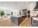 The expansive kitchen island with stone counters and stainless appliances looks into the living area with fireplace feature at 1830 Commodore St, Charlotte, NC 28205