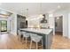 Modern kitchen features a large island with seating, gray cabinets, stainless steel appliances and light wood flooring at 1830 Commodore St, Charlotte, NC 28205