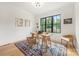 Office features a wooden desk, a large window overlooking nature and a colorful patterned rug on the hardwood floors at 1830 Commodore St, Charlotte, NC 28205