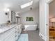 A bathroom with double sink and white cabinets and tub at 202 Walden Ln, Weddington, NC 28104