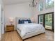 This bedroom features a large window, a king bed, and hardwood floors at 202 Walden Ln, Weddington, NC 28104
