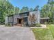 Striking modern home with black and gray siding, manicured landscaping, and a welcoming front entrance at 202 Walden Ln, Weddington, NC 28104