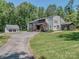 Lovely landscaped front exterior with a modern design, detached garage and mature trees at 202 Walden Ln, Weddington, NC 28104