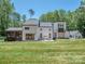 Expansive back exterior showcasing a screened porch, large patio area, and well-manicured lawn at 202 Walden Ln, Weddington, NC 28104