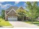 Beautiful two-story home featuring a stone and brick facade, three-car garage, and well-manicured lawn at 2100 Goddard Way, Waxhaw, NC 28173