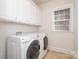 Functional laundry room featuring a washer, dryer, tile flooring, and white cabinets at 2100 Goddard Way, Waxhaw, NC 28173