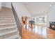 Open-concept living space flows from staircase to the kitchen featuring hardwood floors, fireplace, and grand piano at 2100 Goddard Way, Waxhaw, NC 28173