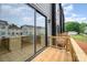 A wood deck features a glass slider and wooden railing, offering a view of the surrounding neighborhood at 212 Mattoon St, Charlotte, NC 28216