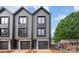 Modern townhouse exterior features dark siding, black framed windows, and a garage with clear glass panels at 212 Mattoon St, Charlotte, NC 28216