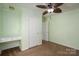 Light green bedroom featuring a built-in desk, ceiling fan, and carpet flooring at 219 E Boston Ave # 141516, Bessemer City, NC 28016