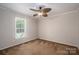 Neutral bedroom with tan paneled walls, carpet flooring, and a ceiling fan at 219 E Boston Ave # 141516, Bessemer City, NC 28016