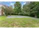 A spacious, gravel-covered backyard with mature trees and landscaping offering a serene and private outdoor space at 220 Low Water Bridge Rd, Troy, NC 27371