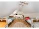 Spacious bedroom loft featuring wood floors, ceiling fan, and two beds at 220 Low Water Bridge Rd, Troy, NC 27371