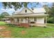 Quaint farmhouse featuring a metal roof and a spacious porch, perfect for enjoying the outdoors at 220 Low Water Bridge Rd, Troy, NC 27371