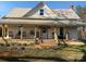 Charming two-story home featuring a welcoming front porch with wooden pillars and a metal roof at 220 Low Water Bridge Rd, Troy, NC 27371
