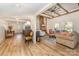 Open-concept living area with exposed beams, hardwood floors, and a cozy fireplace, creating a warm and inviting space at 220 Low Water Bridge Rd, Troy, NC 27371