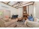 Cozy living room with exposed beams, brick fireplace, and comfortable seating arrangement at 220 Low Water Bridge Rd, Troy, NC 27371