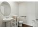 Bathroom features a pedestal sink, round mirror, and a convenient grab bar for safety and accessibility at 2282 Redstone Dr, York, SC 29745
