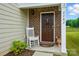 Inviting front entrance with a rocking chair, brown front door, and decorative wreath at 2282 Redstone Dr, York, SC 29745