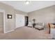 Bright bedroom featuring neutral walls, carpeted floors, closet, two chairs and side table at 282 Harrison Ln, Locust, NC 28097