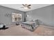 Cozy bedroom with a ceiling fan, window, and comfortable bed with patterned bedding at 282 Harrison Ln, Locust, NC 28097