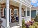 Inviting front porch featuring stone accents, white columns, and comfortable seating with plants at 282 Harrison Ln, Locust, NC 28097