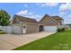 Rear exterior showing a detached garage and extended driveway at 282 Harrison Ln, Locust, NC 28097