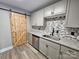 This kitchenette features a modern design with gray cabinets, granite counters, stainless steel appliances and barn door access at 3824 Freedom Dr, Charlotte, NC 28208