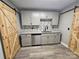 This kitchenette features a modern design with gray cabinets, granite counters, stainless steel appliances and barn door access at 3824 Freedom Dr, Charlotte, NC 28208