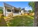 Spacious backyard featuring a wooden fence, lush green grass, and covered porch at 3949 Plainview Rd, Charlotte, NC 28208