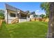 Expansive backyard featuring a wooden fence, lush green grass, and covered porch at 3949 Plainview Rd, Charlotte, NC 28208