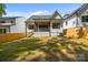 Green backyard featuring a privacy fence, covered porch and mature trees at 3949 Plainview Rd, Charlotte, NC 28208