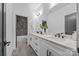 Bathroom with double vanity, modern fixtures, and access to a tiled shower with niche at 3949 Plainview Rd, Charlotte, NC 28208