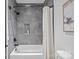 Modern bathroom featuring sleek gray tile, a soaking tub, and modern fixtures at 3949 Plainview Rd, Charlotte, NC 28208