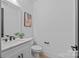 Modern half bathroom with white marble countertop, and stylish fixtures in a clean, minimalist design at 3949 Plainview Rd, Charlotte, NC 28208