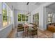 Bright dining room features a modern chandelier, large windows, and a rustic wooden table at 3949 Plainview Rd, Charlotte, NC 28208