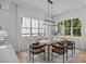 Bright dining room featuring a wooden table beneath a modern chandelier and large windows at 3949 Plainview Rd, Charlotte, NC 28208
