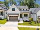 Charming exterior of a white modern farmhouse featuring a gray garage and landscaped front yard at 3949 Plainview Rd, Charlotte, NC 28208