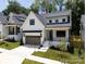 Charming two-story home with a white exterior, gray garage door, and well-manicured lawn at 3949 Plainview Rd, Charlotte, NC 28208