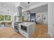 Open-concept kitchen featuring an island with quartz countertop, a range hood, and an adjacent living area at 3949 Plainview Rd, Charlotte, NC 28208