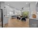 Bright, open-concept kitchen and living area with hardwood floors, modern appliances, and stylish furniture at 3949 Plainview Rd, Charlotte, NC 28208