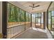 Relaxing screened porch with ceiling fan, offering tranquil outdoor living with a view of the lush, green surrounding trees at 3949 Plainview Rd, Charlotte, NC 28208