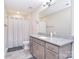 Bathroom featuring a granite countertop vanity, large mirror, and a shower with neutral patterned curtain at 4017 Avis Way, Monroe, NC 28110