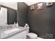 Stylish powder room with dark walls, granite sink and charming decorative accents at 4017 Avis Way, Monroe, NC 28110
