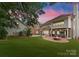 Expansive backyard features a lush lawn, a fire pit, and elegant brickwork under a stunning sky at 4023 Alexandra Alley Dr, Charlotte, NC 28210