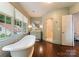 Well-lit bathroom featuring a standalone tub with a view, a glass-walled shower, and a vanity at 4023 Alexandra Alley Dr, Charlotte, NC 28210