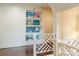Bright hallway featuring decorative railings, hardwood floors, and a built-in bookshelf at 4023 Alexandra Alley Dr, Charlotte, NC 28210