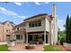 Rear of house with outdoor fireplace, covered patio, outdoor kitchen, and well-manicured synthetic grass lawn at 4023 Alexandra Alley Dr, Charlotte, NC 28210