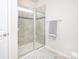 Bright bathroom shows modern glass shower doors and neutral tile at 411 Lahinch Dr, Tega Cay, SC 29708
