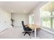 Bright bedroom featuring neutral carpeting, a desk setup, ample natural light and walk in closet at 411 Lahinch Dr, Tega Cay, SC 29708
